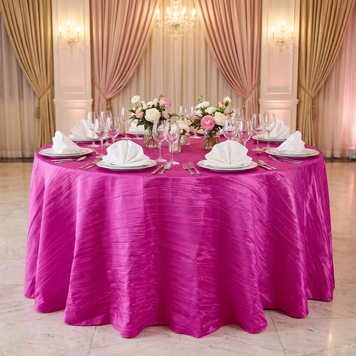 Accordion Crinkle Taffeta Round Tablecloth Fuchsia on a round table paired with white napkins in a fan fold, water goblets and floral centerpieces