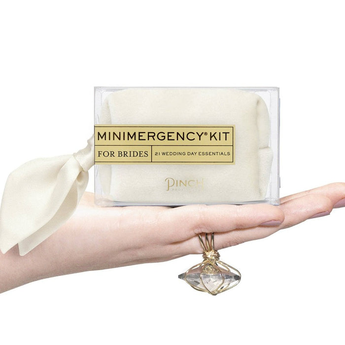 Bride holding ivory Minimergency Kit for Brides with wedding day essentials and perfume pendant