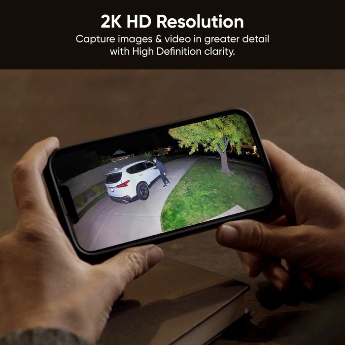 A smartphone captures a video of a man walking in front of a car at night.