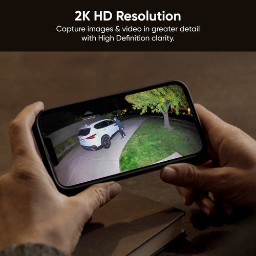 A smartphone captures a video of a man walking in front of a car at night.