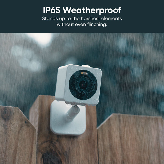 A white camera attached to a wooden fence.