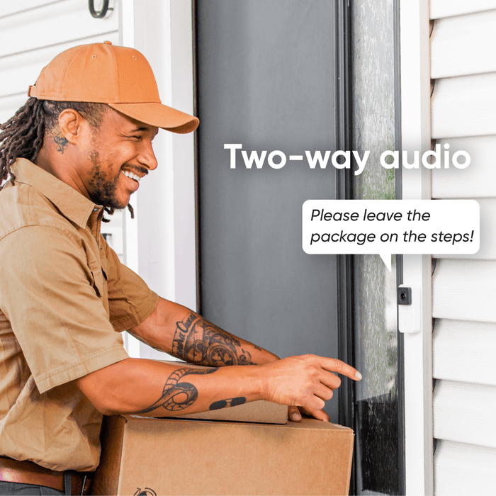 A man in a brown shirt is holding a box with a Wyze Video Doorbell in it.