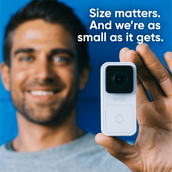 A man is holding a white Wyze Video Doorbell.