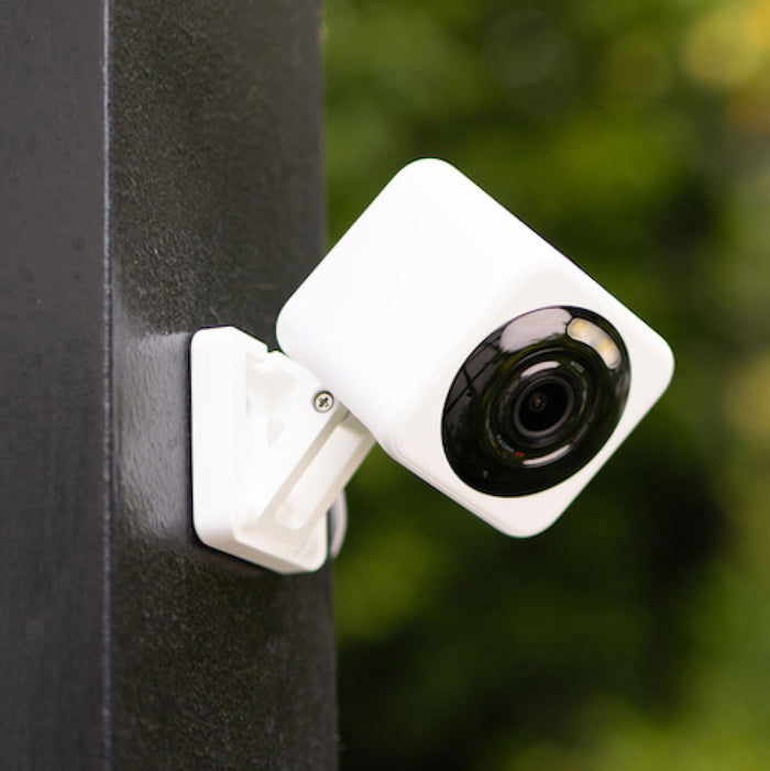 A security camera kit is displayed on a black pole.