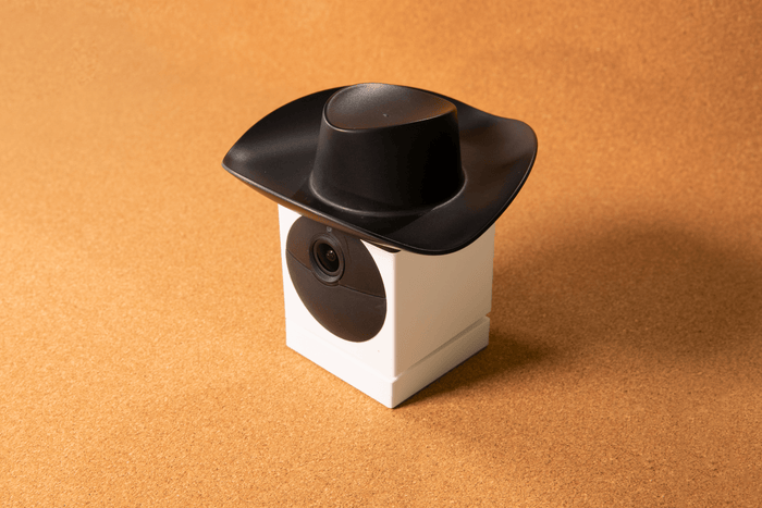 A black and white cowboy hat with a camera attached to it.