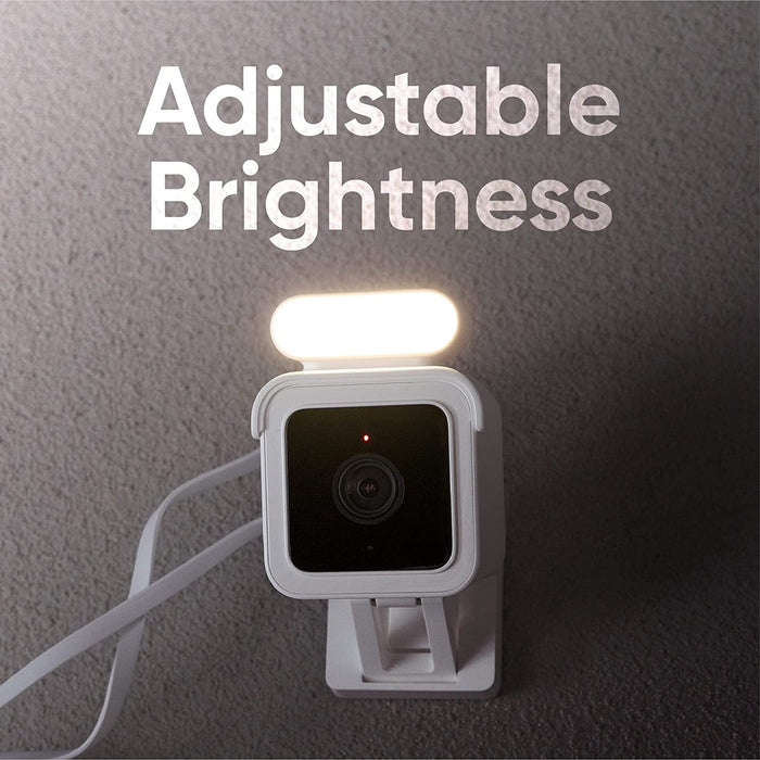 A white and black camera with a spotlight kit.
