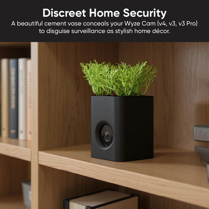 A black vase with a plant in it.