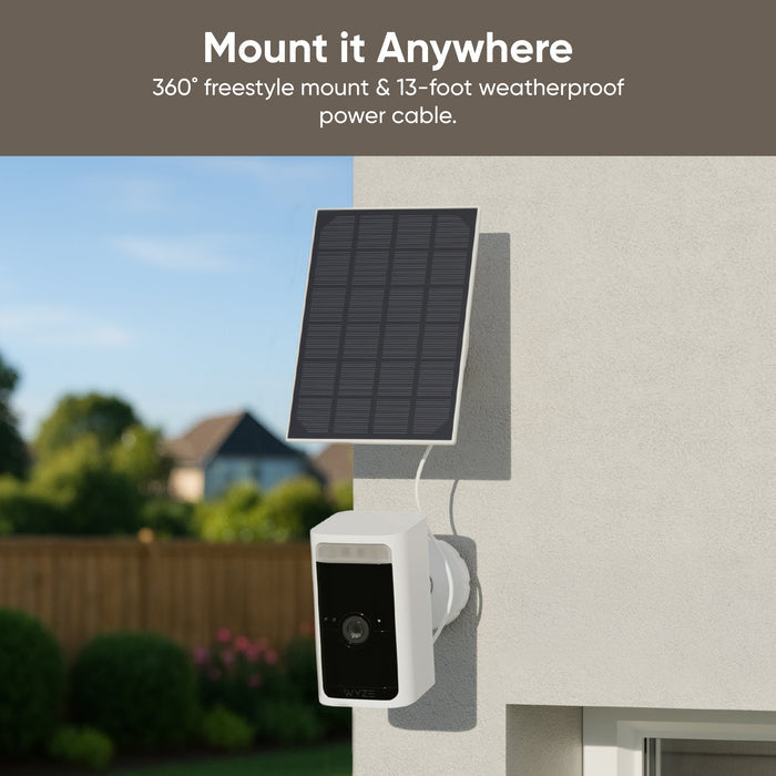 A solar panel is attached to a white wall, providing power to a Wyze Battery Cam Pro.